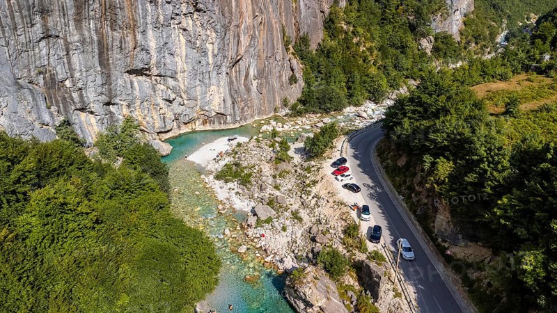 Aerial drone view of small beach on turquoise river of Valbona valley