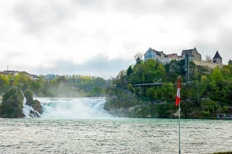 Rhine Falls and Swiss Flag with the Castle Laufen at Neuhausen in Schaffhausen