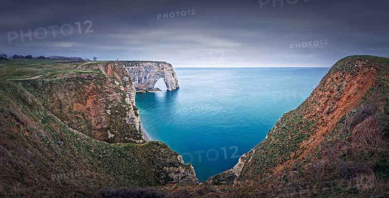 Sightseeing panoramic view to the Porte d'Aval natural arch cliff washed by Atlantic ocean waters at Etretat