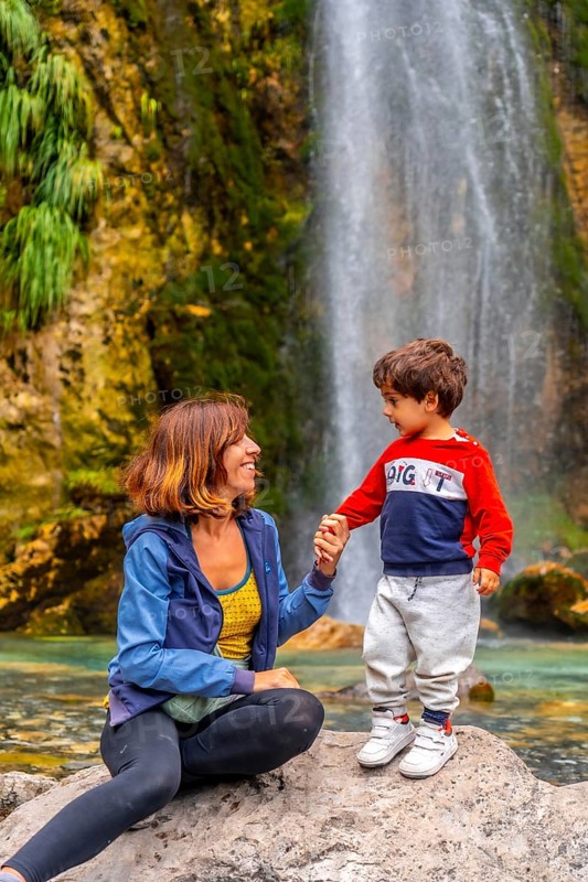 Portrait of mother with her son Grunas waterfall of Theth national park in summer