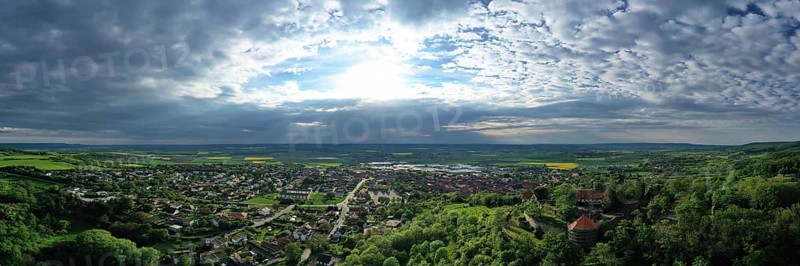 Aerial view of Koenigsberg in Bavaria. The city is surrounded by hills and forests. The sky is cloudy and dark