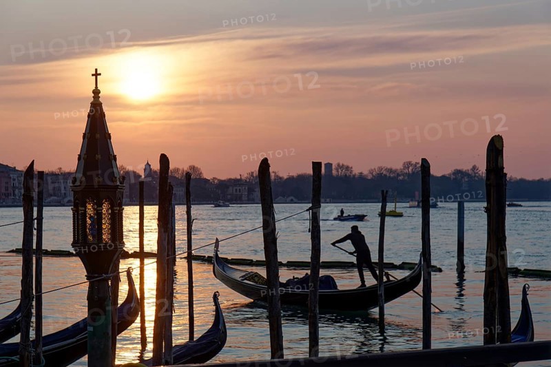 Gondola at sunrise on the Giudecca Canal in front of St Mark's Square
