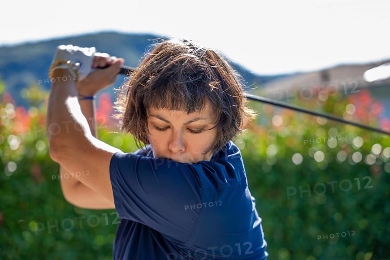Front View on a Female Golfer Making a Golf Swing in a Sunny Day in Switzerland