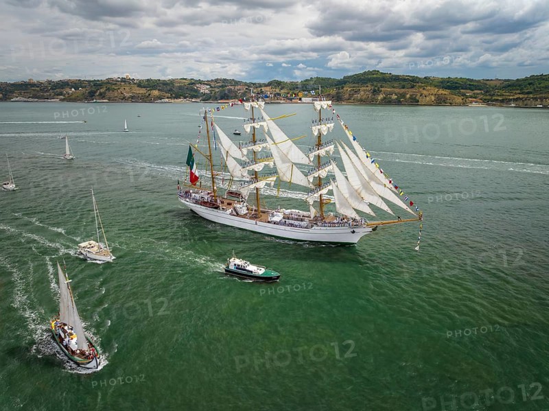 Aerial drone view of tall ships with sails sailing in Tagus river towards the Atlantic ocean in Lisbon