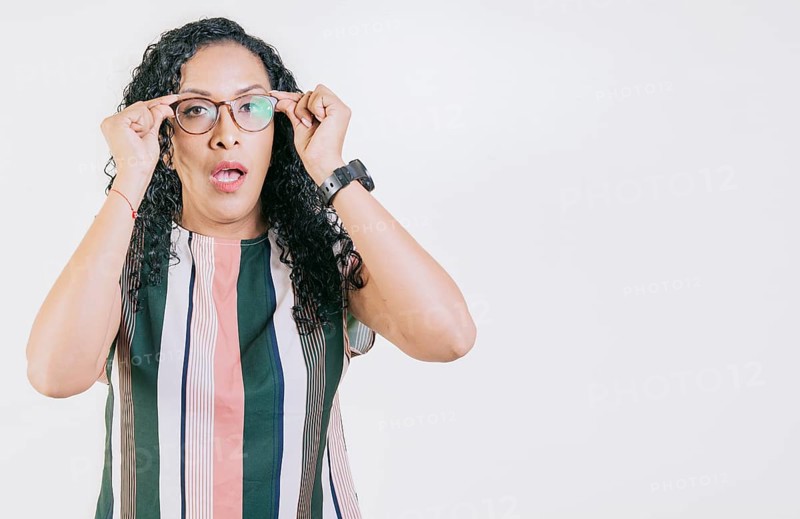 Surprised woman taking off glasses isolated. Amazed afro girl taking off glasses by a promotion