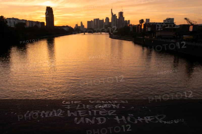 WE CAN FLY. ALWAYS FURTHER AND HIGHER. is written on a railing of the Deutschherrn Bridge in Frankfurt's Osthafen area