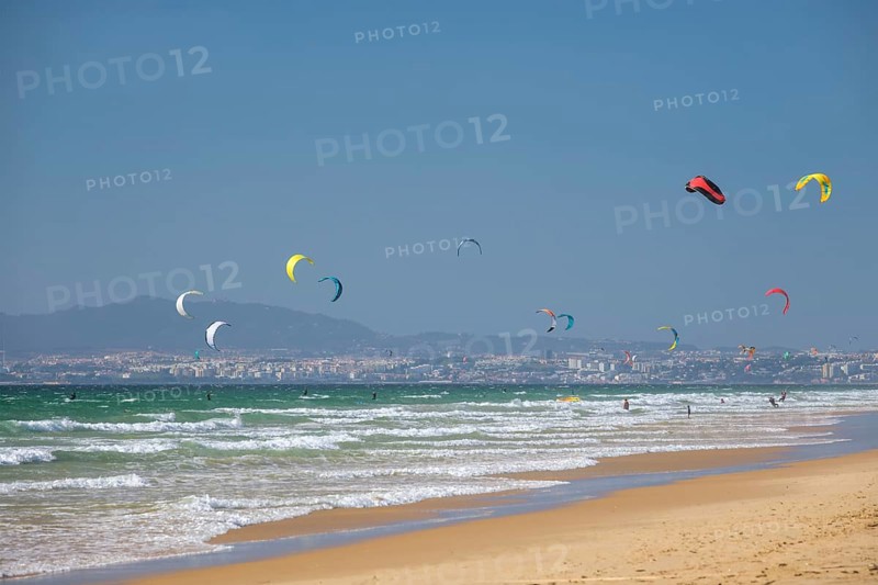 Kiteboarding kitesurfing kiteboarder kitesurfer kites on the Atlantic ocean beach at Fonte da Telha beach