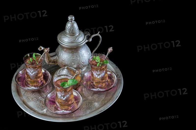 Tray with Moorish tea with mint and silver pitcher and sugar bowl isolated on black background and copy space