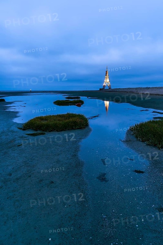 Kugelbake illuminated with water reflection at dusk