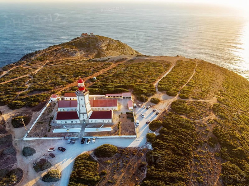 Aerial drone view of lighthouse on Cabo Espichel cape Espichel on Atlantic ocean at sunset. Sesimbra