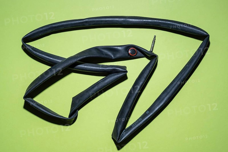 Top view of a flat bicycle tube against a blue background