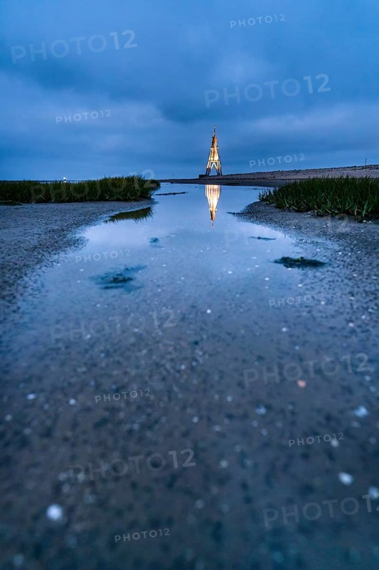 Kugelbake illuminated with water reflection at dusk