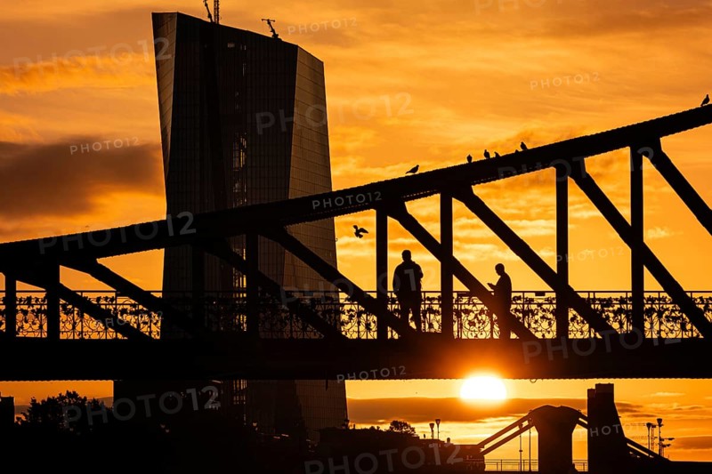 The sun rises behind the European Central Bank
