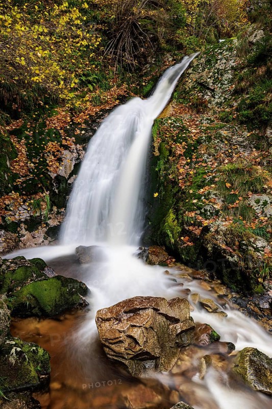 Mountain stream with waterfalls in autumn