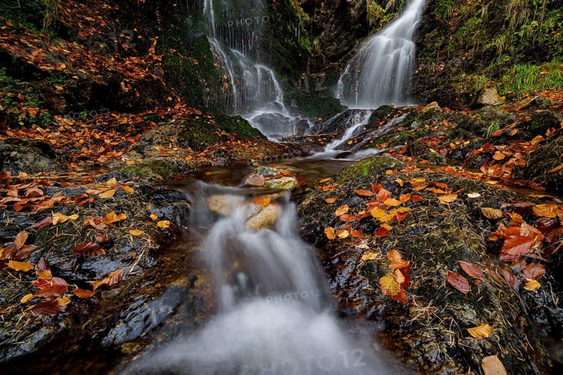 Mountain stream and waterfall in autumn forest