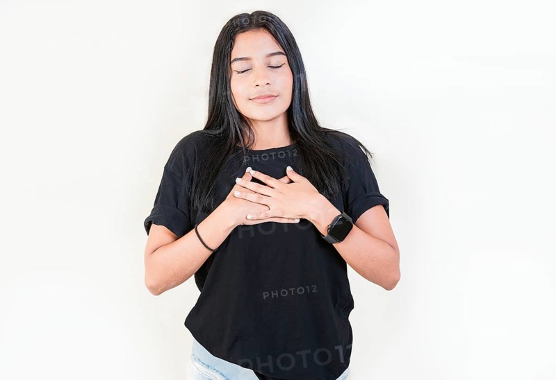 Thankful people with hands on chest. Grateful teenage girl smiling with hands on chest isolated. Positive latin girl with hands on chest