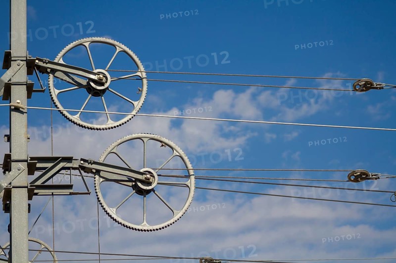 Railway line mast with wheel tensioning station