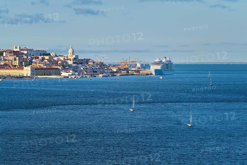 View of Lisbon over Tagus river from Almada with yachts tourist boats and moored cruise liner on sunset. Lisbon