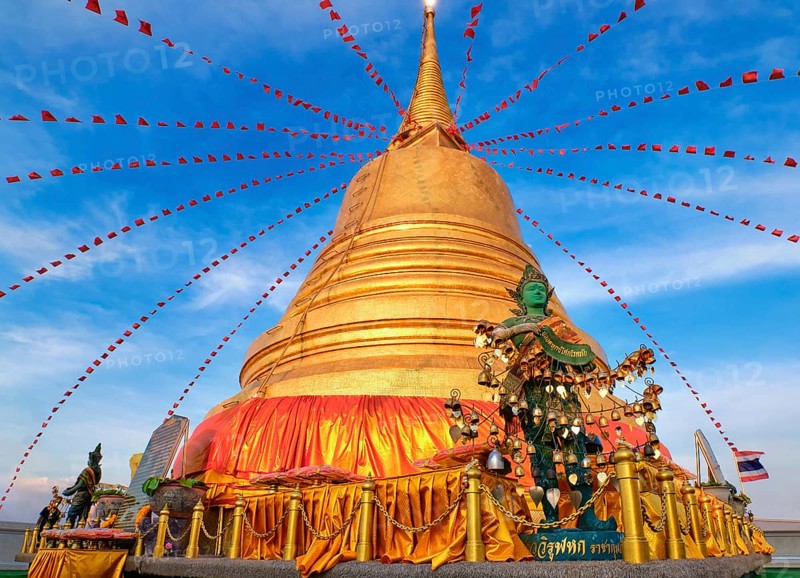 Statue of green-skinned Thai angel holding roll with message in Thai