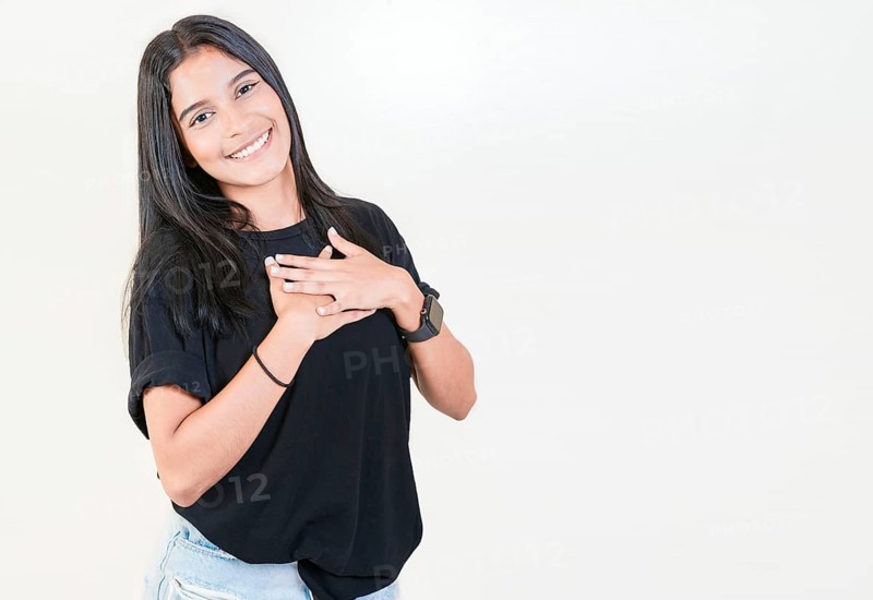 Grateful teenage girl smiling with hands on chest isolated. Positive latin girl with hands on chest. Thankful people with hands on heart