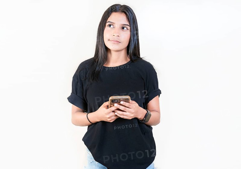 Thoughtful attractive girl holding phone isolated. Pensive latin girl holding smart phone on white background