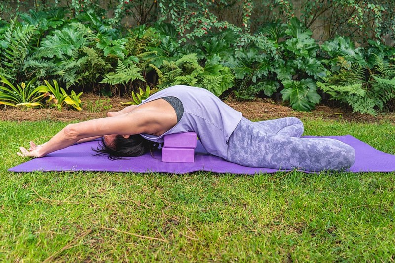 Woman relaxing on yoga blocks. Copy space