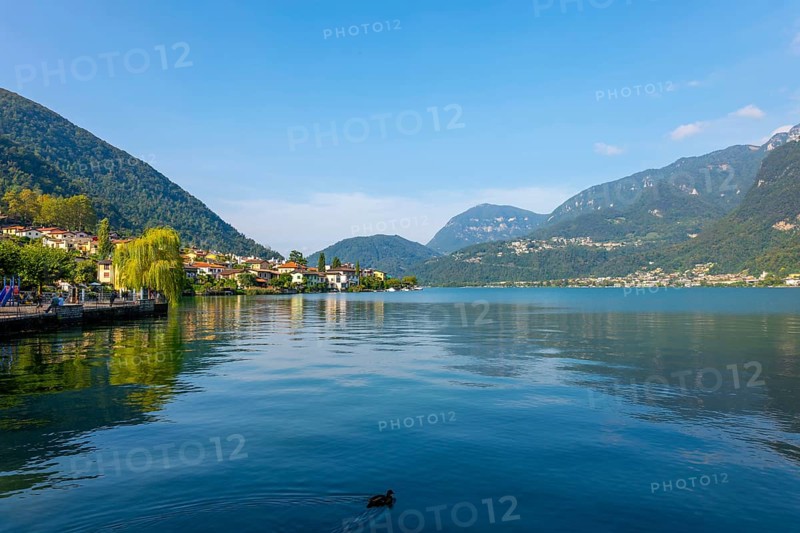 Waterfront in City of Riva San Vitale with Mountain View on Lake Lugano in a Sunny Summer Day in Riva San Vitale