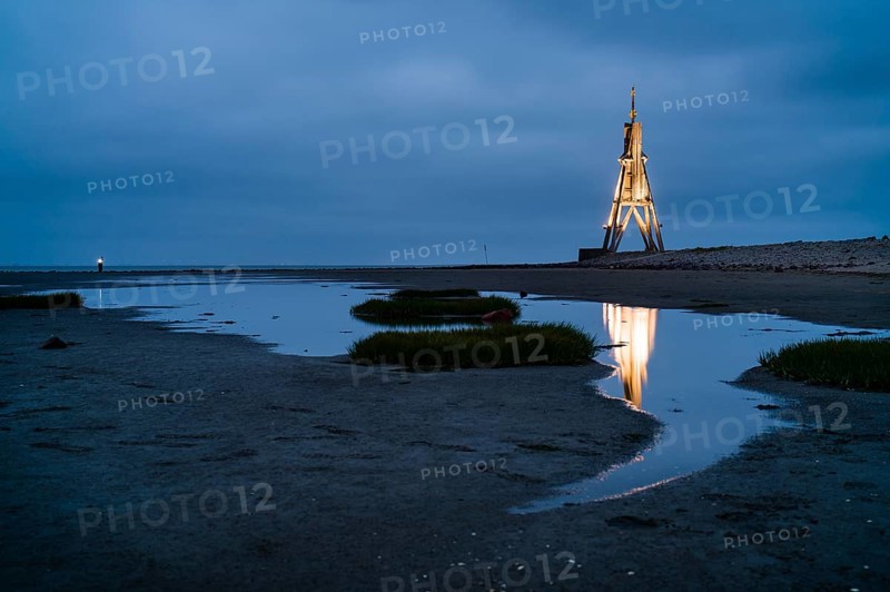 Kugelbake illuminated with water reflection at dusk