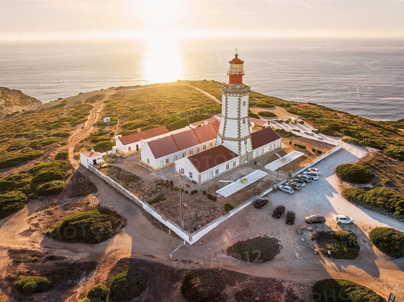 Aerial drone view of lighthouse on Cabo Espichel cape Espichel on Atlantic ocean at sunset. Sesimbra