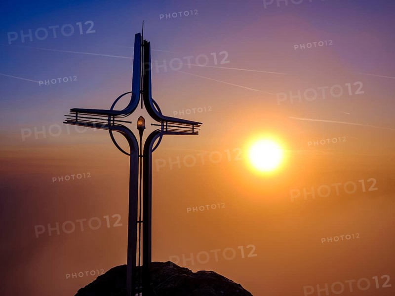 Summit cross Hoher Goell in the fog at sunrise