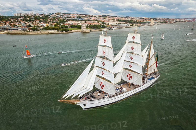 Aerial drone view of tall ships with sails sailing in Tagus river towards the Atlantic ocean in Lisbon