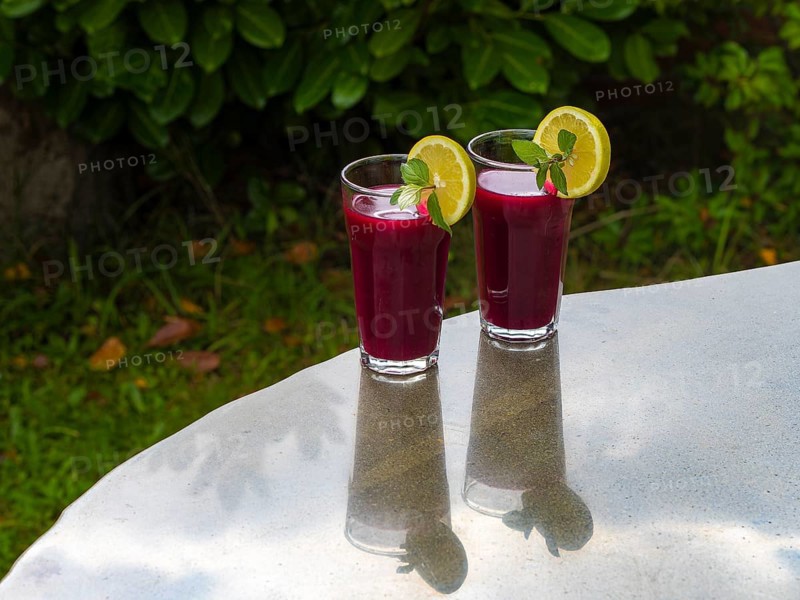 Freshly squeezed juice of beetroot with apple and lemon in a juice glass