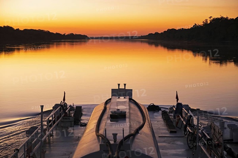 Boat sailing on the on the Mamore River at sunset in the Amazon basin