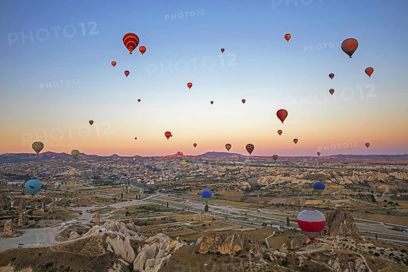 Hot air balloons flying over Cappadocia at sunrise