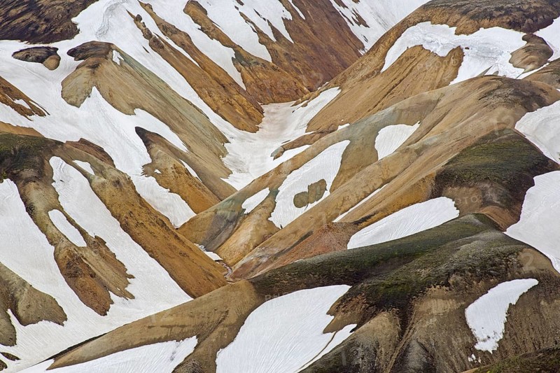 Sulphur coloured rhyolite mountains with patches of snow at Brennisteinsalda volcano near Landmannalaugar