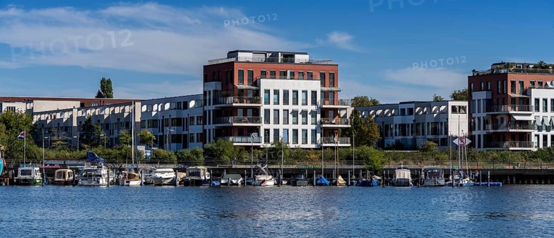 Illegally anchored houseboats in the Rummelsburg Bay with the residential houses on the Rummelsburg shore