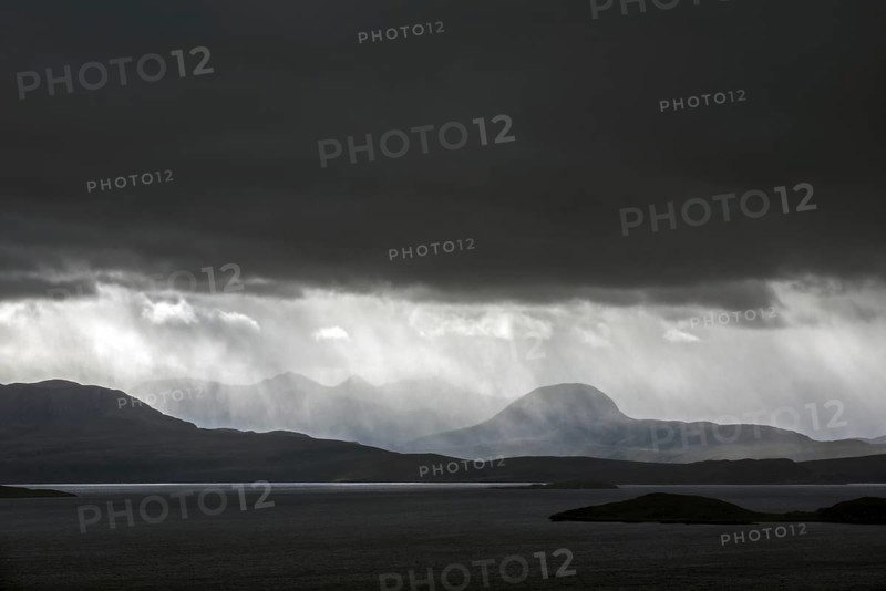 Black stormy sky and downpour during rain storm over desolate wilderness of Coigach
