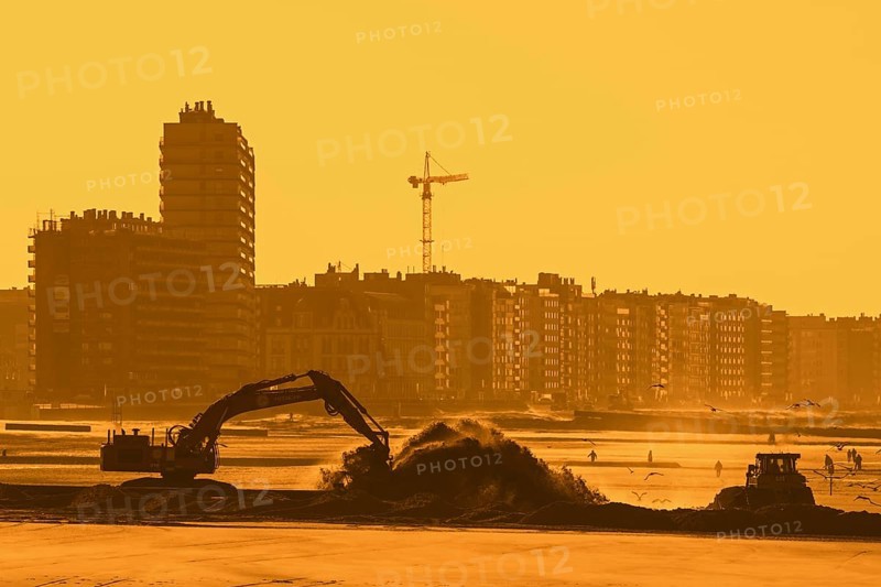 Bulldozer and hydraulic excavator installing pipeline during sand replenishment