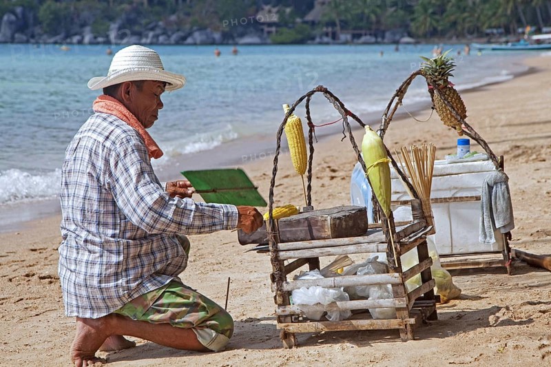 Beach vendor preparing corn on tiny portable barbecue on the island Ko Tao