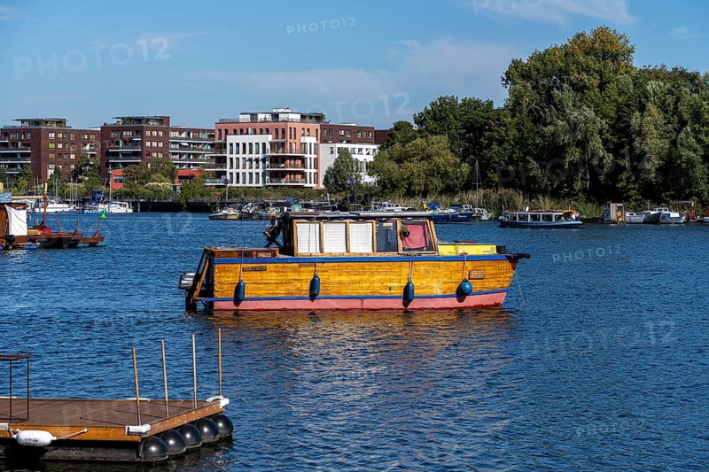 Illegally anchored houseboats in the Rummelsburg Bay with the residential houses on the Rummelsburg shore