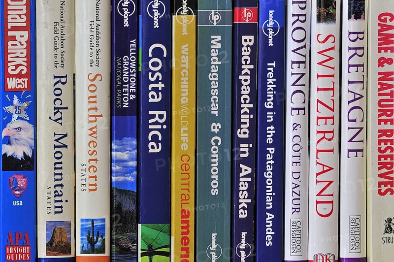 Collection of travel guides about worlwide holiday destinations on a bookshelf
