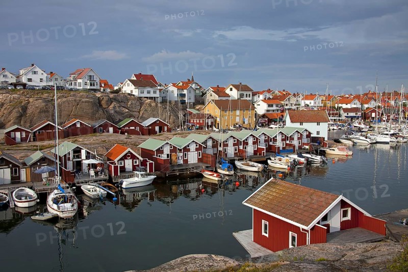 Colourful traditional fishing huts and boathouses along wooden pier at Smoegen
