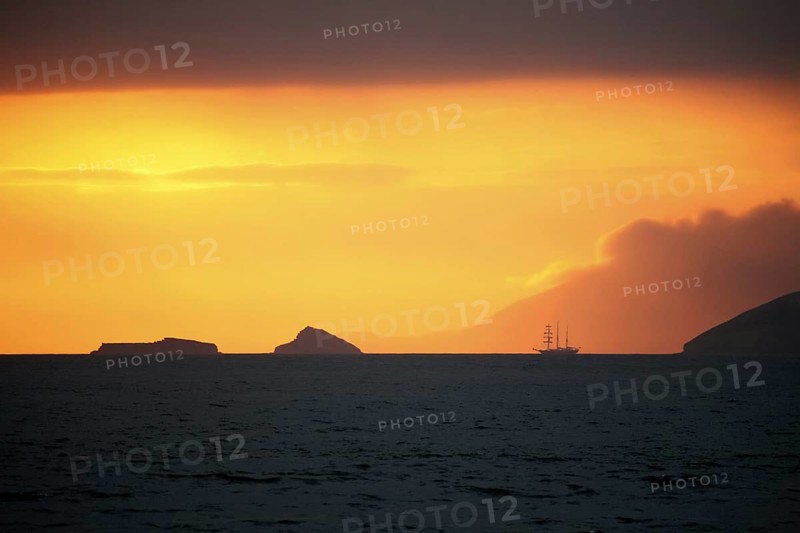 Three-master sailing ship at sunset in front of Santiago Island