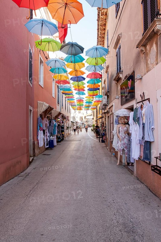 Alley with colourful umbrellas suspended over a street