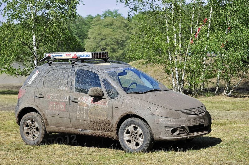 Suzuki SX4 four-wheel drive off-road vehicle covered in mud after rally racing