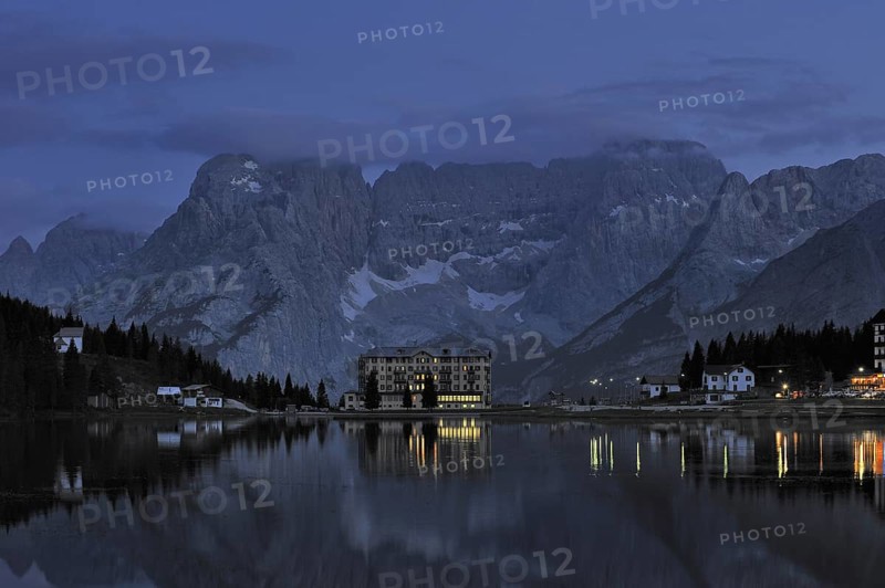 The mountain range Gruppo del Sorapis and hotels at night along lake Lago di Misurina in Auronzo di Cadore