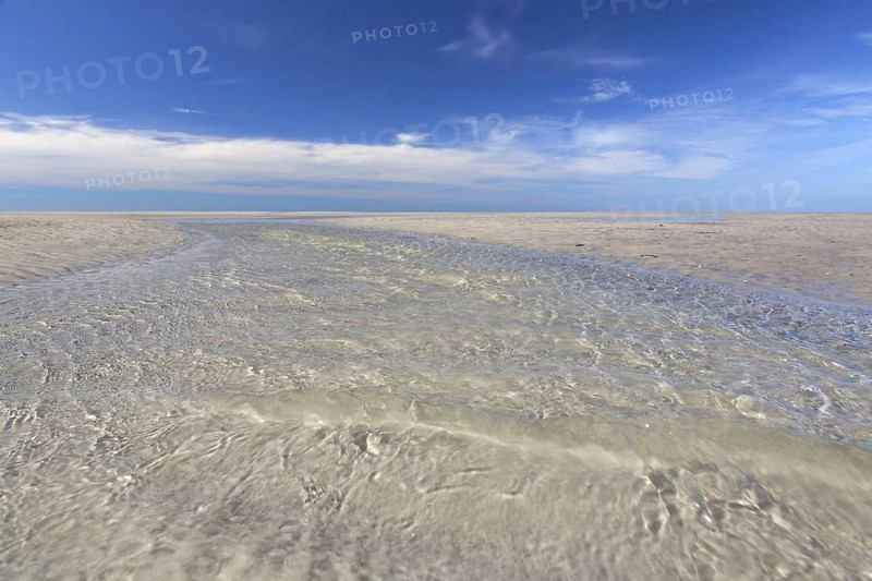 Water flowing through tidal creek into the Wadden Sea along the German North Sea coast
