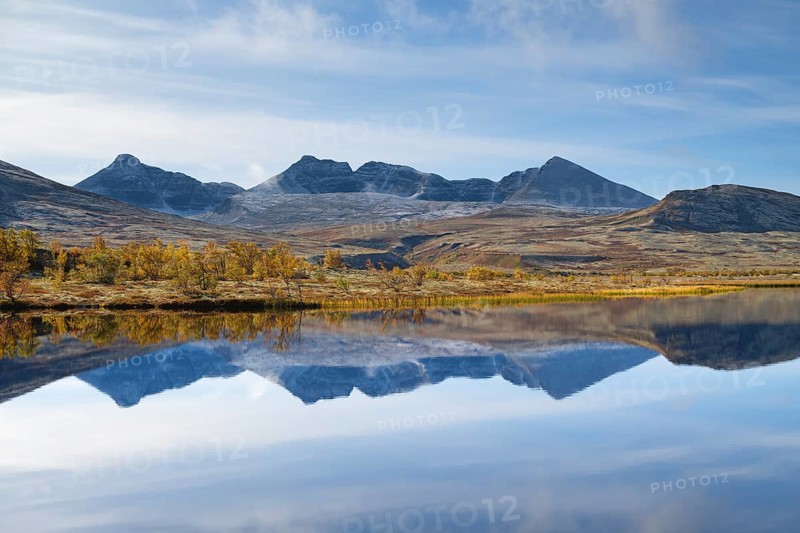 The mountains Hogronden and Digerronden reflected in the water of a lake