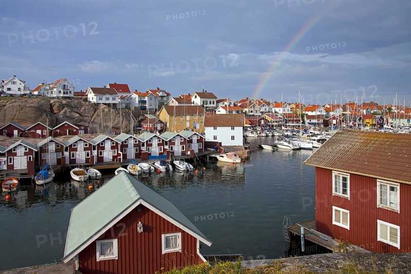 Colourful traditional fishing huts and boathouses along wooden pier at Smoegen