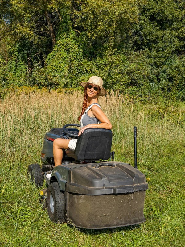 Woman driving lawn mower